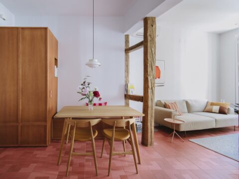 Un llamativo suelo rojo de WOW cerámica en la reforma de una vivienda en Madrid